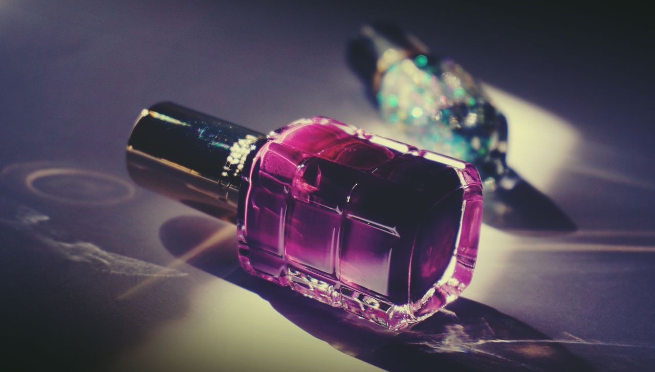 services-01 Artistic close-up of a pink nail polish bottle with reflective light and vivid colors.