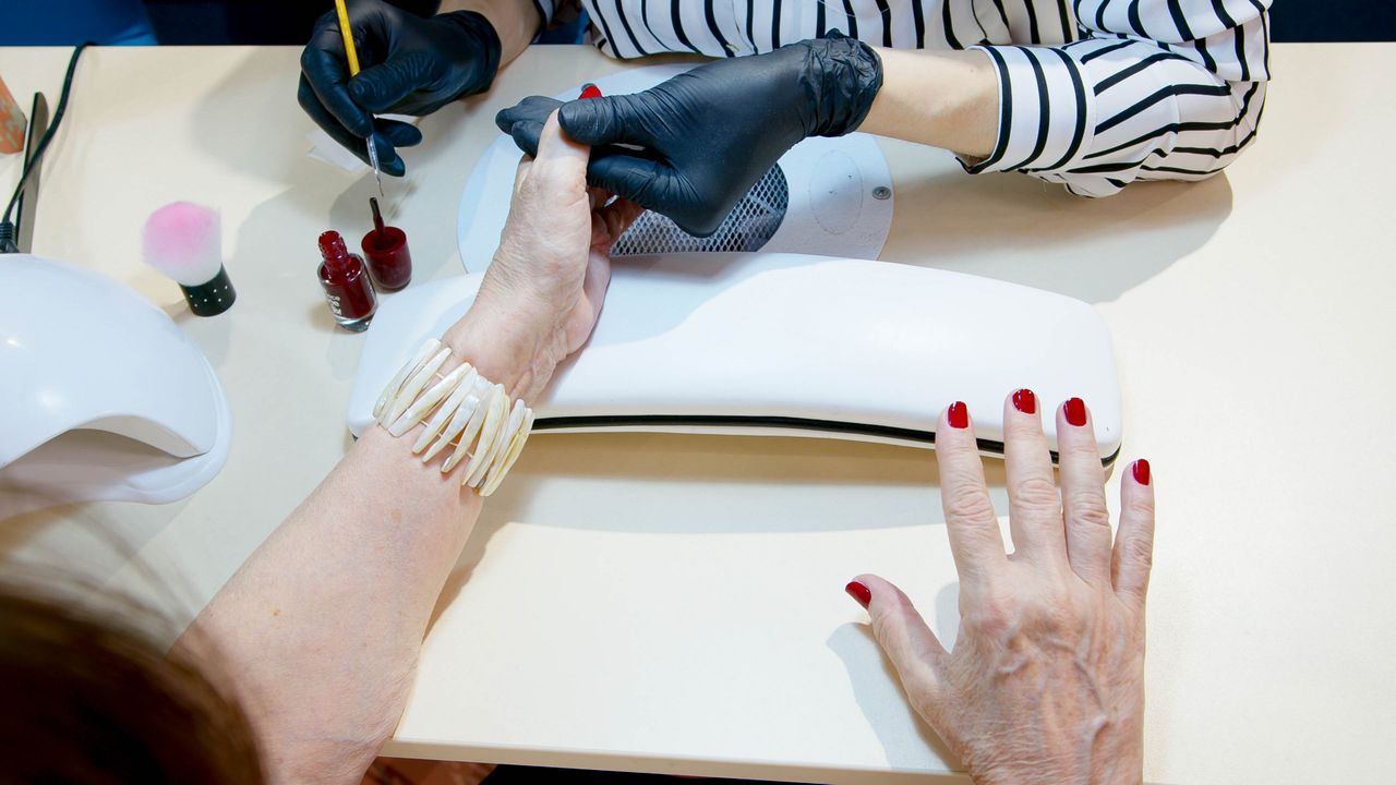 services-04 Top view of a professional manicure session with red nail polish application in a modern salon.